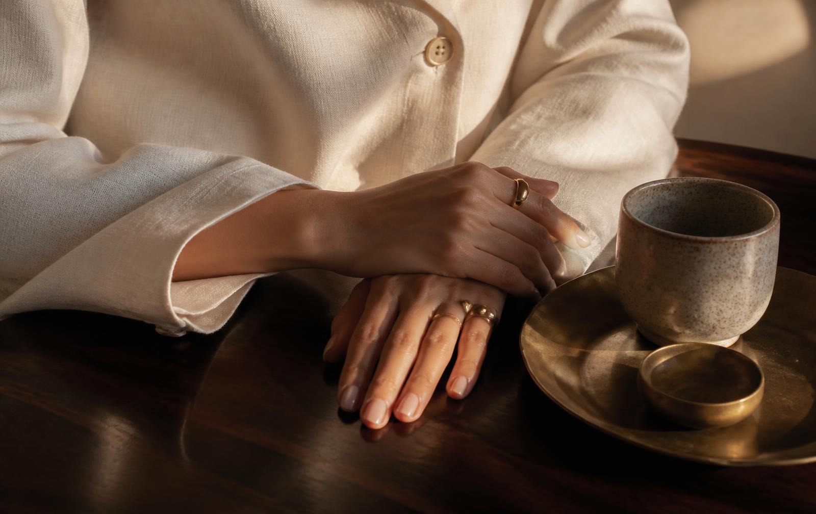 Hands resting on linen against warm limestone