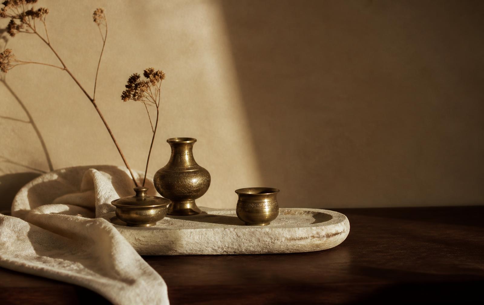 Brass bowls and ritual details on warm stone in low sunlight